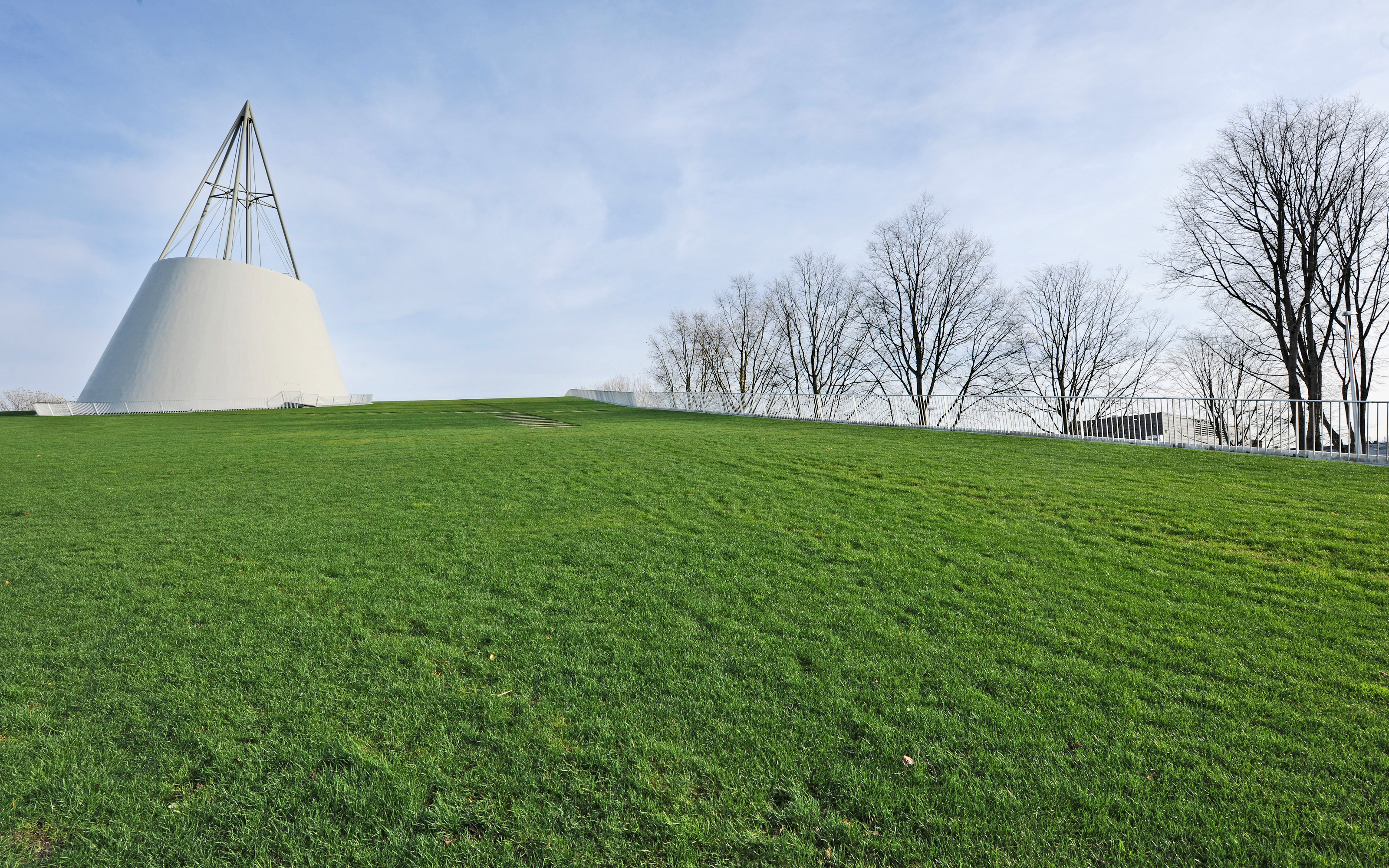 The library is topped by a huge steel cone as a symbol of technical engineering. Large green roof with lawn